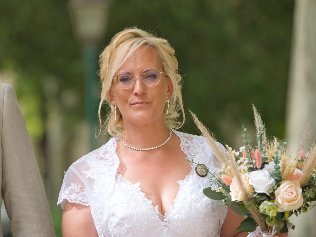 la mariée porte un bouquet de fleurs