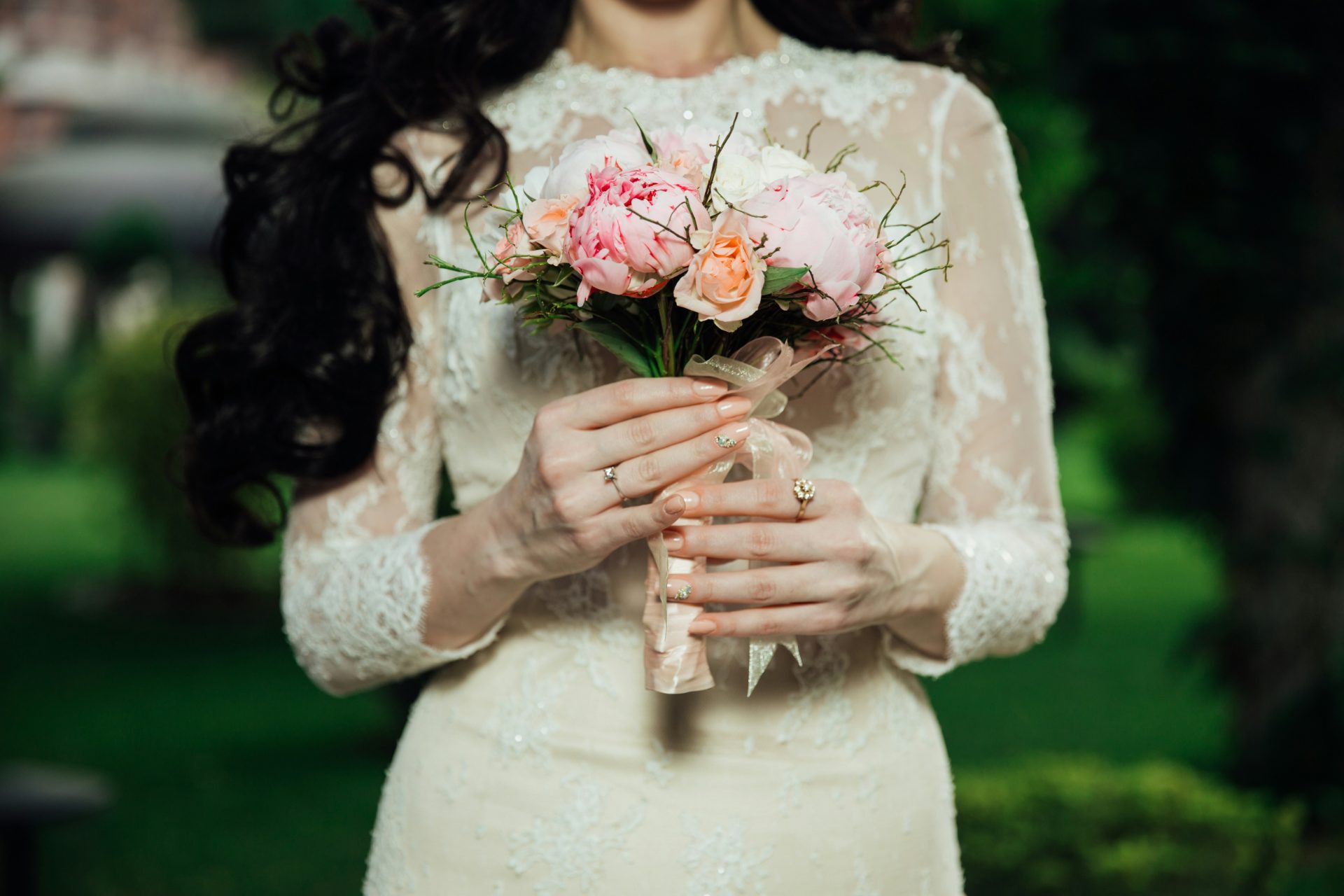 Une mariée présente son bouquet en robe de mariée